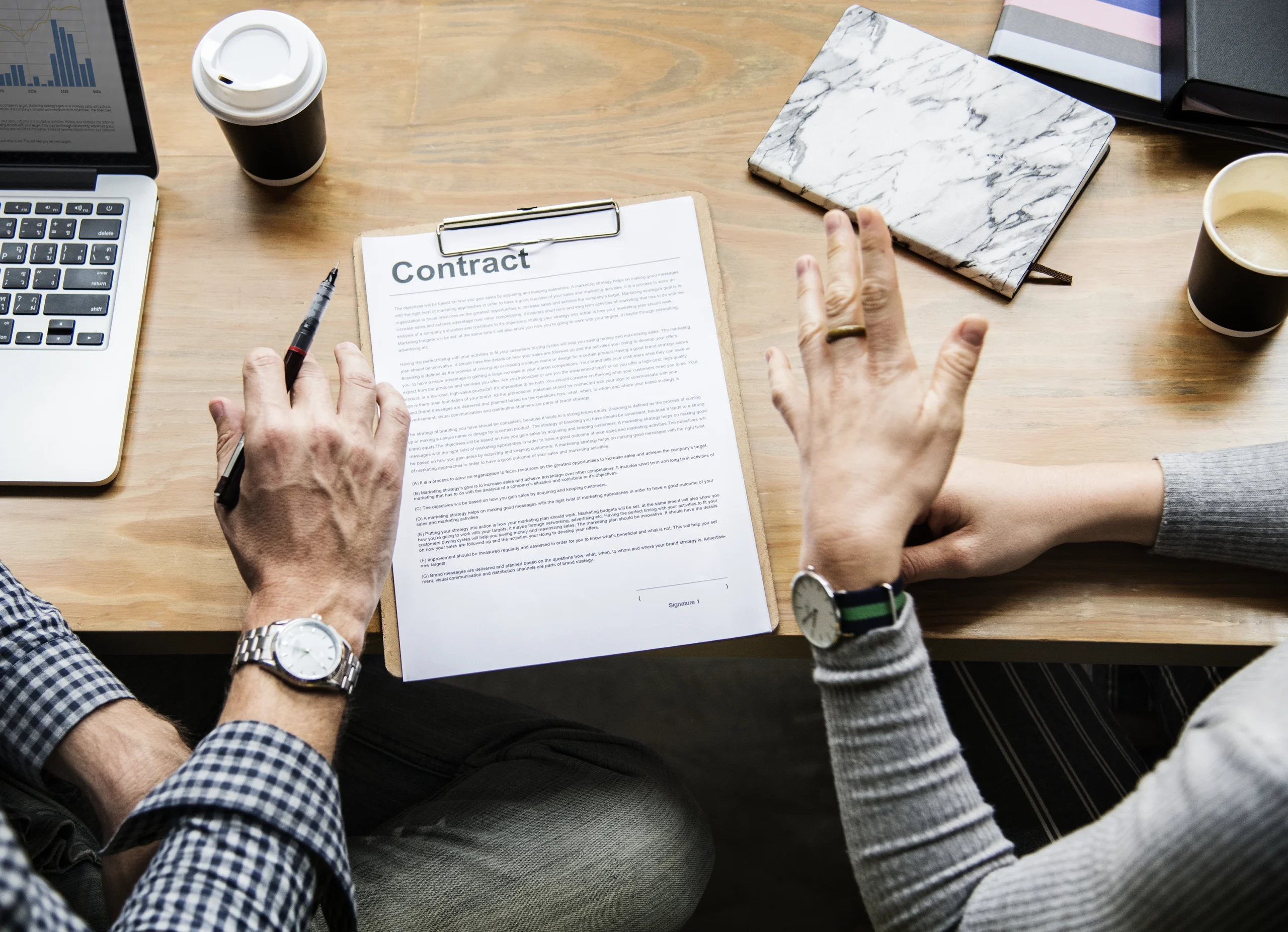 Image of two people sitting at a desk and in the middle of an IT staff augmentation contract