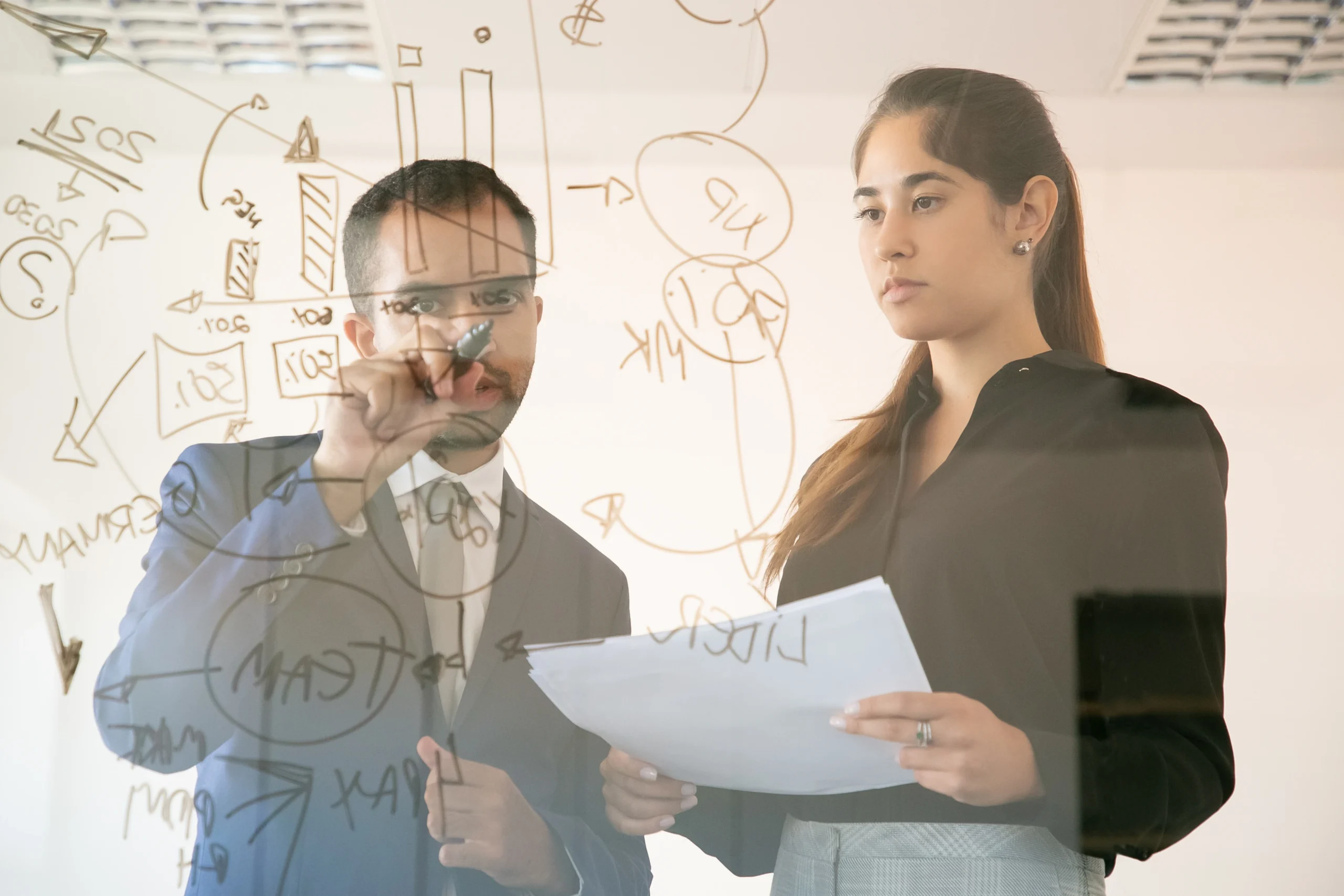 Image of two people in front of a board designing a possible IT staff augmentation project