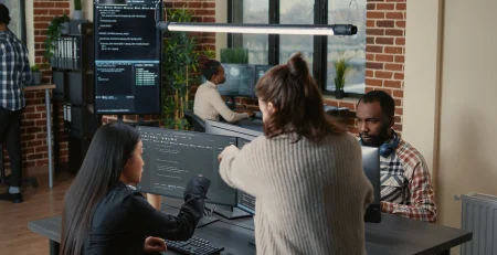 group of people working in an office referencing embrace Custom Software Solutions