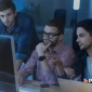 Three IT professionals analyzing data on a computer screen, representing the key IT profiles that boost business technology in modern organizations.