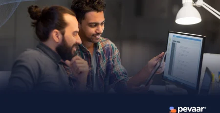 Two developers discussing a digital interface on a tablet and desktop, illustrating IT governance and strategy for startups in a tech workspace.