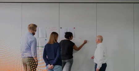 Team collaborating on a whiteboard to design a Power Automate workflow, discussing data structures and how to flatten an array for easier processing.