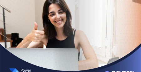 Smiling woman in front of her computer, representing the successful approval of a time off request through automation.