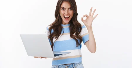 Happy young woman in front of a laptop using project management.