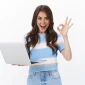 Happy young woman in front of a laptop using project management.