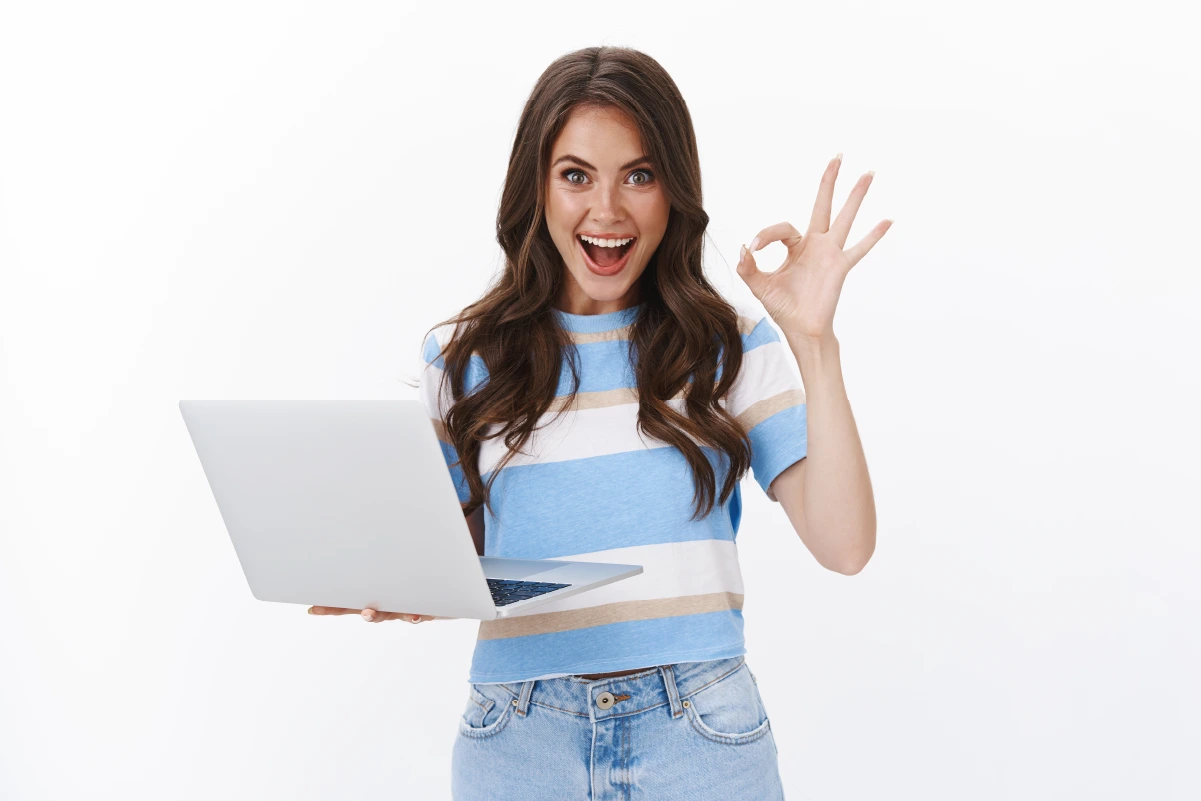 Happy young woman in front of a laptop using project management.