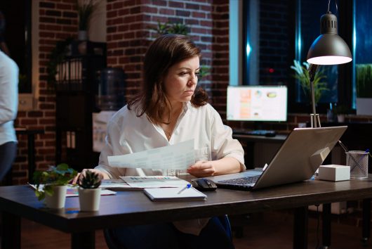 Businesswoman researching for company project, looking through paperwork files. Employee looking over accounting figures on financial documents late at night in brick wall office SSUCv3H4sIAAAAAAAAA01Ry47bMAz8F50tVLZkPXLcAj330NuiB0qiE2Edy7DkLoLA/146cbbVSeQMyeHwzlJkJ6bCYNG3imMYgCutBm6dQy47b7yRnUXVsYZFqMhOrZR9b6W22omuE/Qa5qGkwE53lsZxLXWBmvLEToQsOEVcHl+MqeYlwUjR1rBSoa4FC5VRFKj3mdBH/Or3ft/zJPBtLWnCUr79SBNMAUlMWT0BPzHPI7KteTF/YbhMeczn2xfne77Oa8Wl/Ef7Atn2u2FwxincdiHbrnhEeOh6Z0IOSgox8KhDy5XSjvs2tlyCFq0drNV9pFbggtfOCC4gWK465bjzPnBreqcM1QdURDNaOKE1cNk+uykOvRC8NTFo2QfvukA0HJwD7Cw3pvNcxYgcfBDcKmViD85YKRip/vikpa6Hf7ledptpv7xOdbk9dxxznsGTQacBxoINu0ApRIhHggrnJYU0nY8r0PHy9fmfct1NeFhVc/hI8Rj1PNwlUXafc2frPGaIGA949ddU6ytc8E/Cz3/sbdv+AvWB0yp2AgAA